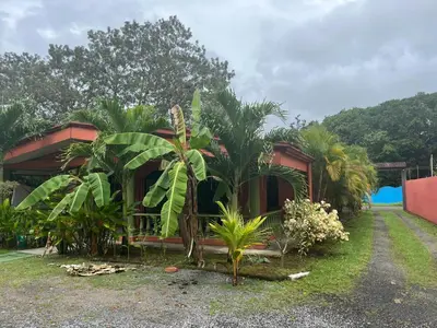 a house with a bunch of plants in front of it at Villa tico House in Cariari