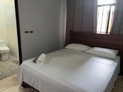 a bedroom with a white bed with a towel on it at Villa tico House in Cariari