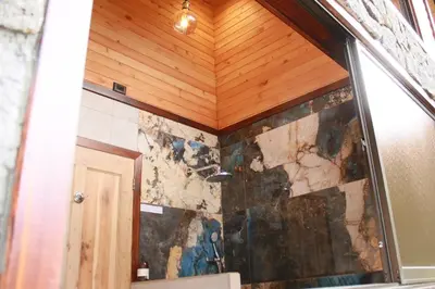 a shower in a bathroom with a wooden ceiling at Casa Buena Vista San Gerardo de Dota in San Gerardo de Dota