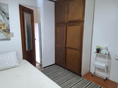 a bedroom with a bed and a wooden door at Habitación cama individual a 10 min del Aeropuerto in Alajuela City