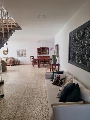 a living room with a couch and a staircase at Habitación cama individual a 10 min del Aeropuerto in Alajuela City