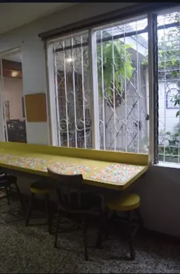 a table and chairs in a room with a window at Habitación cama individual a 10 min del Aeropuerto in Alajuela City