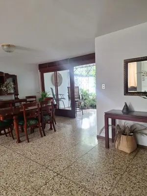 a living room with a table and a dining room at Habitación cama individual a 10 min del Aeropuerto in Alajuela City