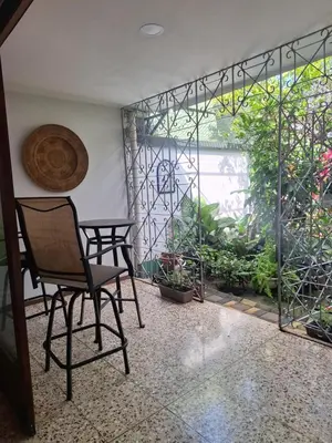 a chair sitting in a room with a large window at Habitación cama individual a 10 min del Aeropuerto in Alajuela City