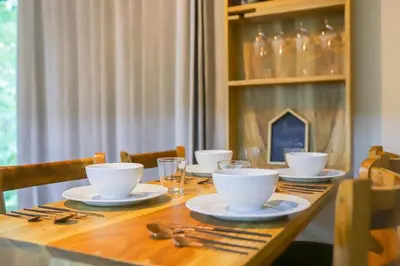a wooden table with white bowls and plates on it at Cabana Nicolia in San Francisco