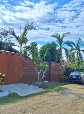 a car parked next to a wooden fence with palm trees at Casa Manglar in Coronado