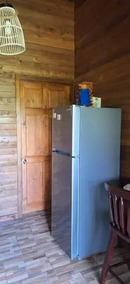 a kitchen with a refrigerator and a wooden wall at Casa Manglar in Coronado