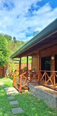 a wooden cabin with a porch and a grass yard at Casa Manglar in Coronado