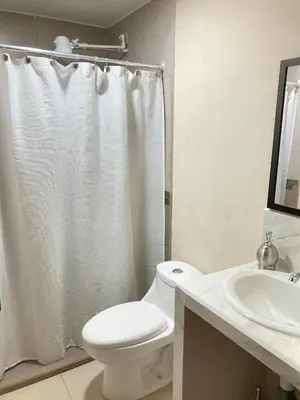 a white bathroom with a toilet and a sink at Hospedaje Ana Lu 3, Only 10 minutes from airport, in Alajuela City