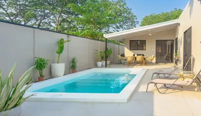 a swimming pool in the backyard of a house at Casa Tres Luces - Samara Home in Nicoya