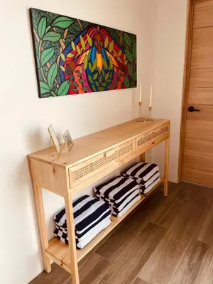 a wooden console table with three folded towels at Casa Tres Luces - Samara Home in Nicoya