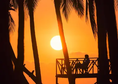 a person riding a horse on the beach at sunset at Hotel Clandestino beach resort in Parrita