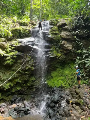 a group of people standing on a trail near a waterfall at Eco-Bamboo Cottages in Turrialba