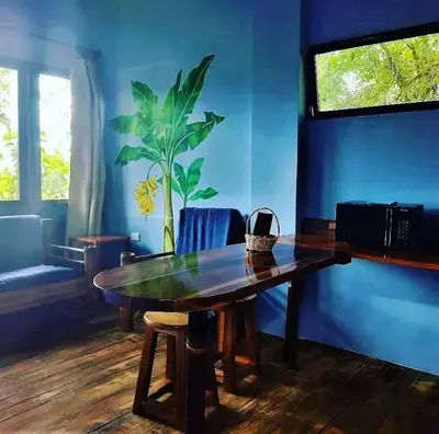 a dining room with a wooden table and blue walls at Eco-Bamboo Cottages in Turrialba
