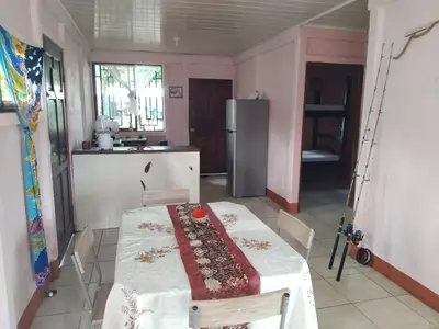 a kitchen with a table and a refrigerator at Monkey Beach House in Tortuguero