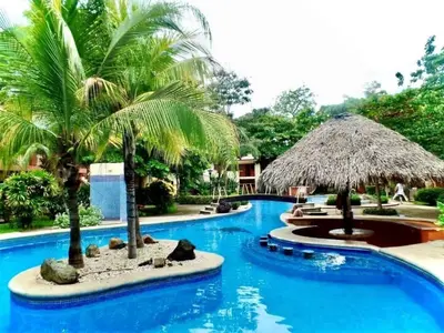 a pool at a resort with palm trees at CocoMarindo in Coco