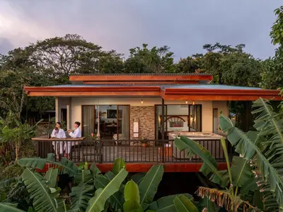 two people standing on the balcony of a house at Villa Alma de Campo Monteverde in Monteverde Costa Rica