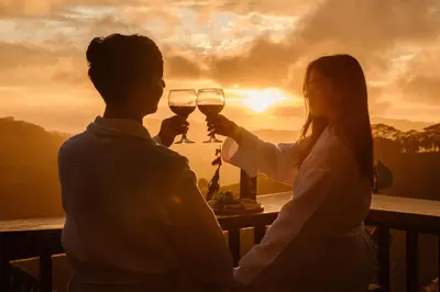a man and woman holding glasses of wine at sunset at Villa Alma de Campo Monteverde in Monteverde Costa Rica