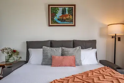 a bed with a gray headboard and pillows at Villa Alma de Campo Monteverde in Monteverde Costa Rica