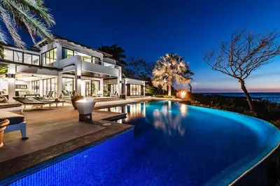 a villa with a swimming pool at night at The Point 5-Star All-Inclusive Experience in Tamarindo