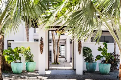 a row of palm trees in front of a white building at The Point 5-Star All-Inclusive Experience in Tamarindo