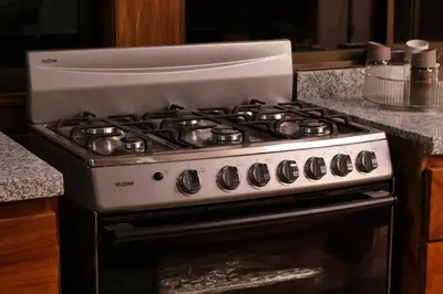 a white stove top oven in a kitchen at Ceiba Hostel in Fortuna