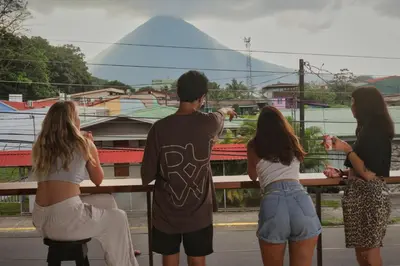a group of people looking at a view of a mountain at Ceiba Hostel in Fortuna