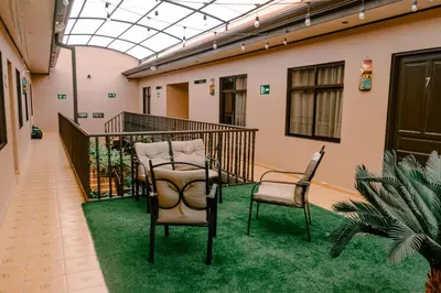 two chairs sitting on a balcony with grass at HOTEL DEL RiO in Liberia