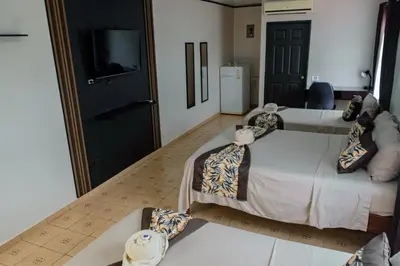 a hotel room with two beds and a television at HOTEL DEL RiO in Liberia