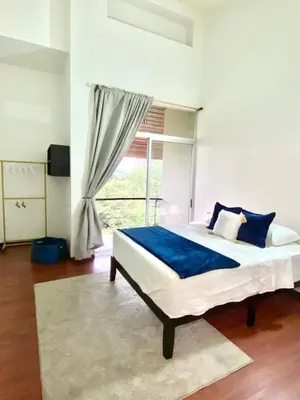 a bedroom with a bed with blue sheets and a window at villa country club cariari in Ciudad Cariari