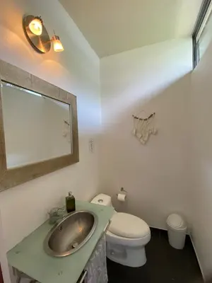 a bathroom with a sink and a toilet and a mirror at villa country club cariari in Ciudad Cariari