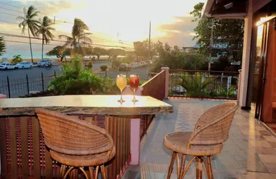a table with two wine glasses on a balcony at Terraza Suite Frente al Mar in Puntarenas