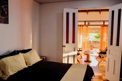 a bedroom with a bed and an open door at Terraza Suite Frente al Mar in Puntarenas