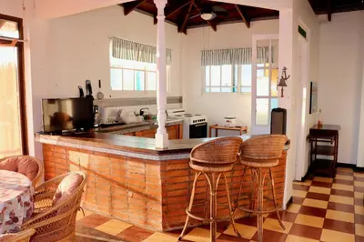 a kitchen with a bar with stools around it at Terraza Suite Frente al Mar in Puntarenas