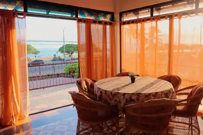 a dining room with a table and a large window at Terraza Suite Frente al Mar in Puntarenas