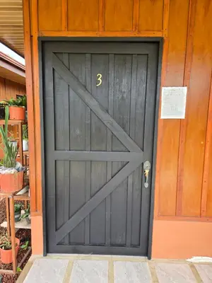 a gray garage door with the number three on it at Rusticas Dani in Tanque