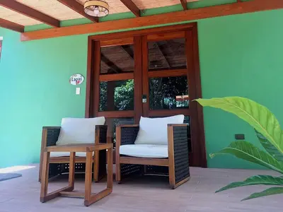 a patio with two chairs and a table and window at Olla é Mono Ecolodge in Sarapiquí