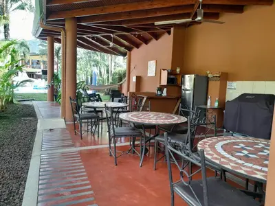 a patio with tables and chairs and a refrigerator at Club Del Cielo Unit 1 in Jacó