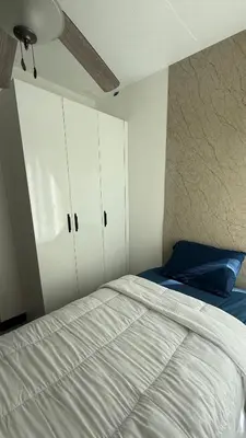 a bedroom with a bed with white cabinets and a blue pillow at Khaya Curridabat in Curridabat