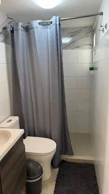 a bathroom with a shower curtain and a toilet at Khaya Curridabat in Curridabat