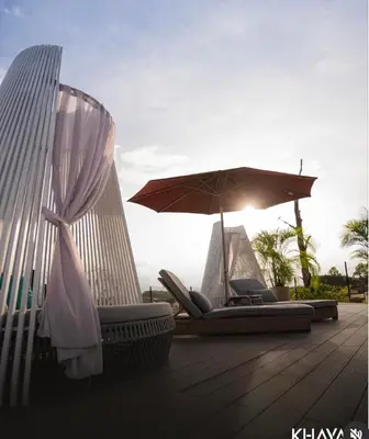 two lounge chairs and an umbrella on a deck at Khaya Curridabat in Curridabat