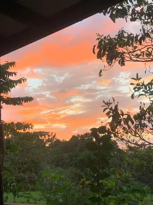 a sunset view from the porch of a house at Finca flo in Carara