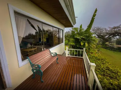 a wooden deck with a bench on the side of a house at Hotel Poas Paradise in Alajuela City