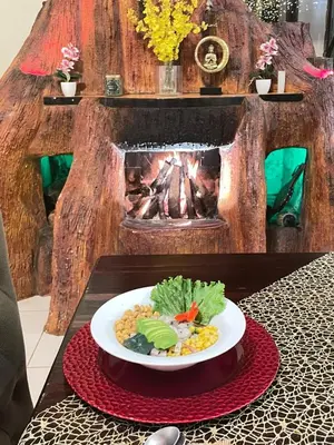 a plate of food on a table with a fireplace at Hotel Poas Paradise in Alajuela City
