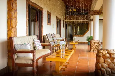 a living room with chairs and a coffee table at Hotel Poas Paradise in Alajuela City
