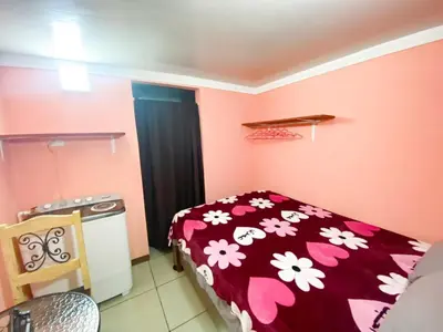 a bedroom with a bed with a red blanket with flowers at Bowen apartamento in Quepos