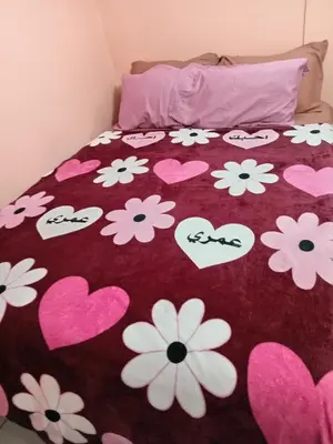 a bed with hearts and flowers on it at Bowen apartamento in Quepos