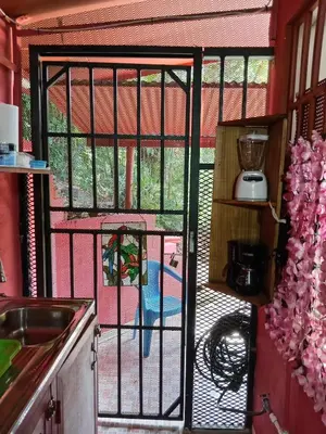 a kitchen with a glass door with a patio at Bowen apartamento in Quepos