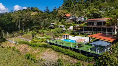 an aerial view of a resort with a tennis court at Glamping Renacer Vistas Turrialba, Paris in Turrialba