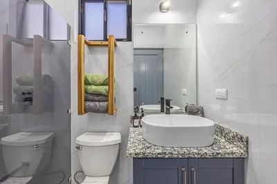 a white bathroom with a sink and a toilet at CASA SERENITY , brand new house, walk 2 beach, private pool, wifi, PURA VIDA!!!! in Uvita